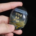 CIRCLEARA "Viva La Vida" etched Blue Tiger's Eye mineral. A tactile grounding tool for calm vitality and gratitude, showcasing natural hawk's eye chatoyancy and gold-leaf lettering.