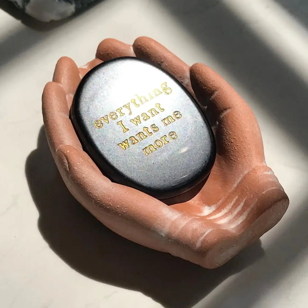 Black manifestation stone with gold engraving 'everything I want wants me more' for meditation and mindfulness