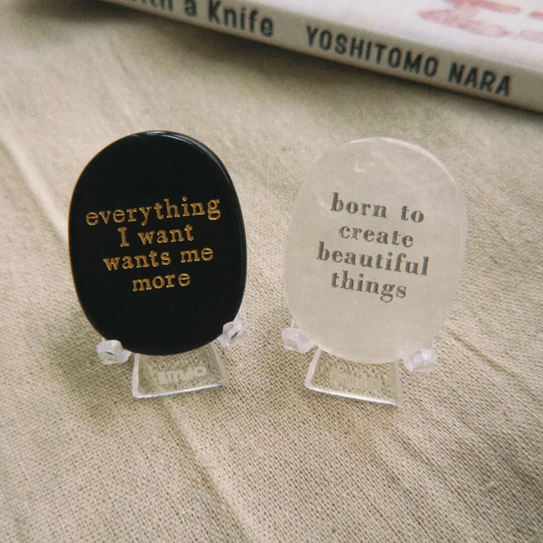 Black manifestation stone with gold engraving 'everything I want wants me more' for meditation and mindfulness