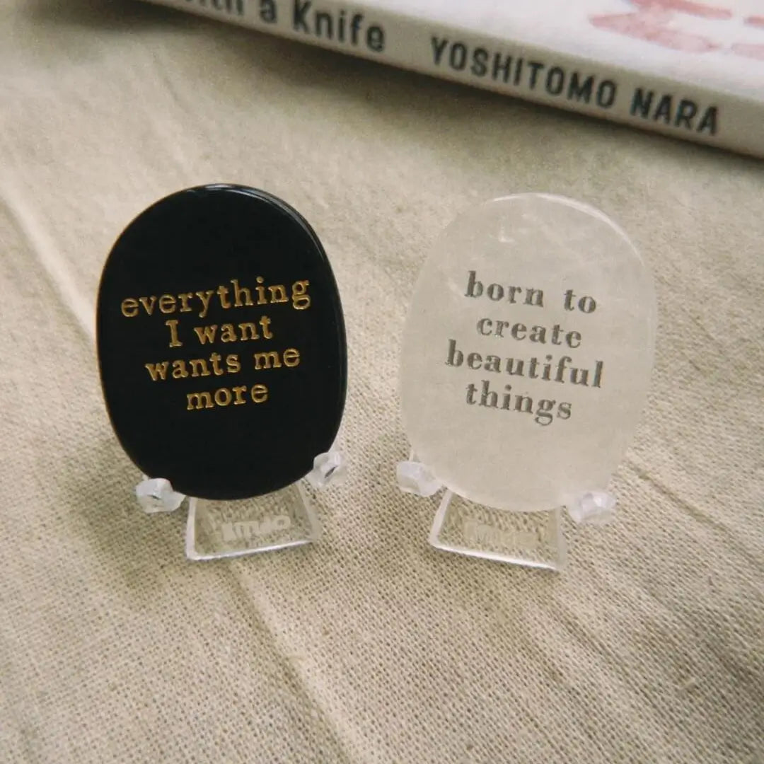 Black manifestation stone with gold engraving 'everything I want wants me more' for meditation and mindfulness