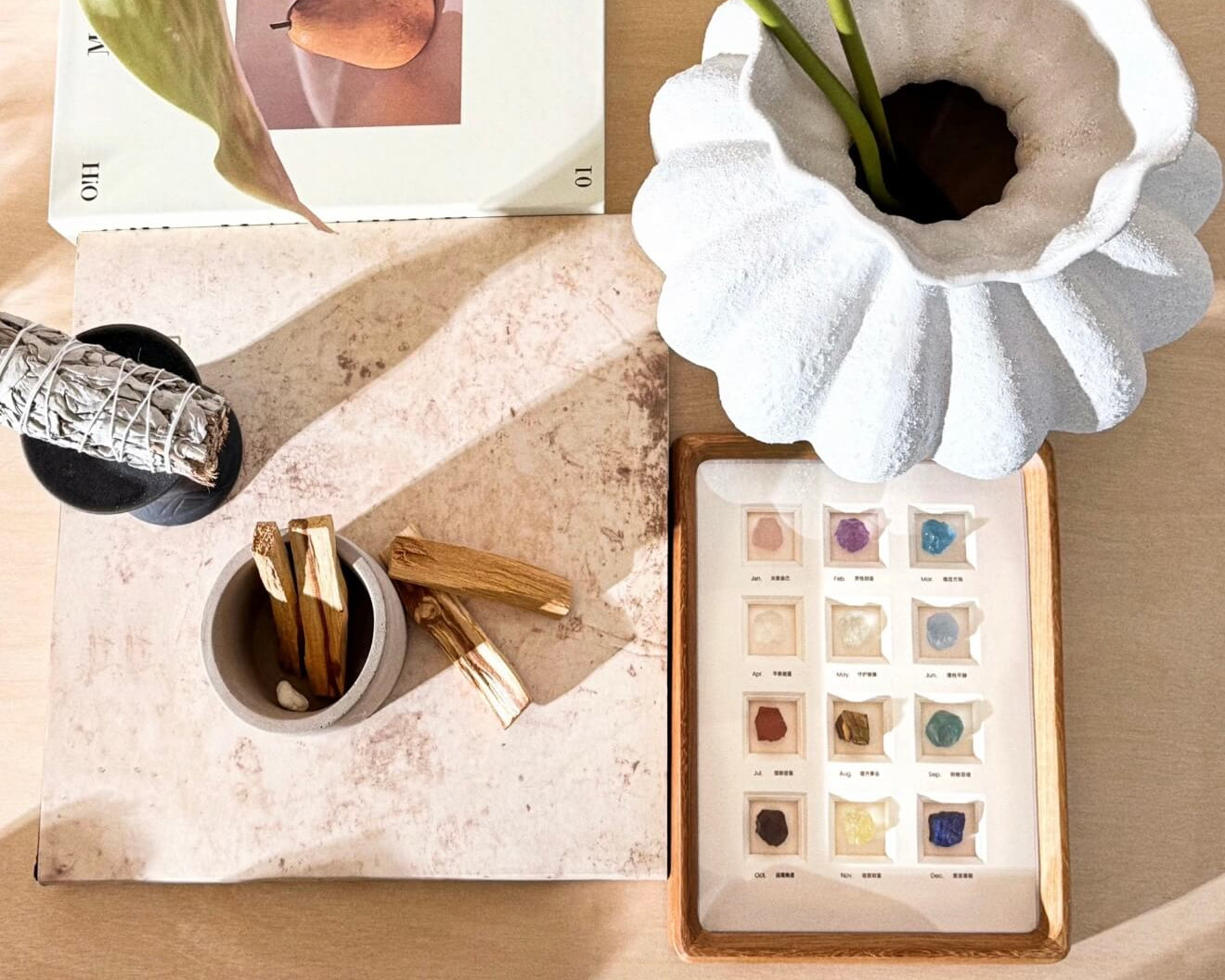 Artisanal ritual objects including zodiac crystal frames, Palo Santo, and white sage to create a personal energy sanctuary and mental clarity space.