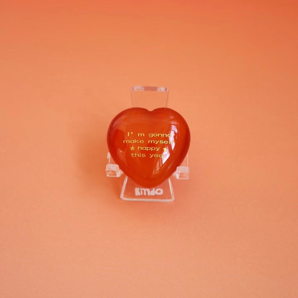 CIRCLEARA "Self-Happy" etched Carnelian heart. A tactile grounding mineral for emotional warmth and vitality, presented as a symbolic 'mental meal' on a dinner plate to represent self-care.