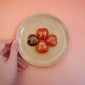CIRCLEARA "Self-Happy" etched Carnelian heart. A tactile grounding mineral for emotional warmth and vitality, presented as a symbolic 'mental meal' on a dinner plate to represent self-care.