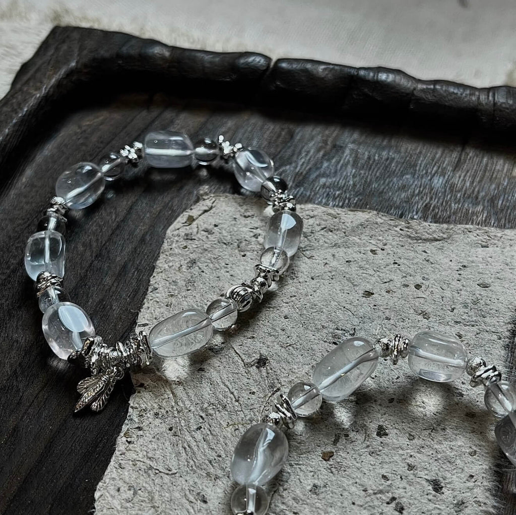 Handcrafted Clear Quartz grounding bracelet featuring smooth, transparent sugar-bean cut crystal beads and 925 sterling silver accents, laid on a clean aesthetic surface.