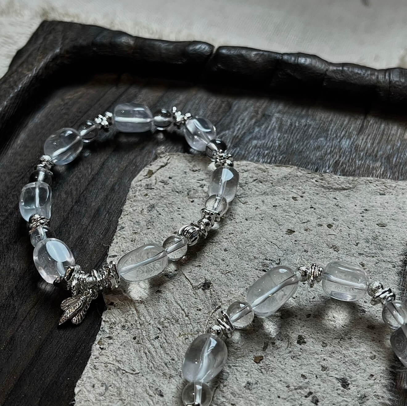 Handcrafted Clear Quartz grounding bracelet featuring smooth, transparent sugar-bean cut crystal beads and 925 sterling silver accents, laid on a clean aesthetic surface.