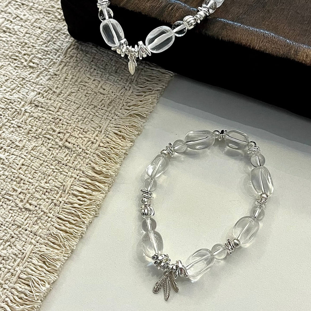 Handcrafted Clear Quartz grounding bracelet featuring smooth, transparent sugar-bean cut crystal beads and 925 sterling silver accents, laid on a clean aesthetic surface.
