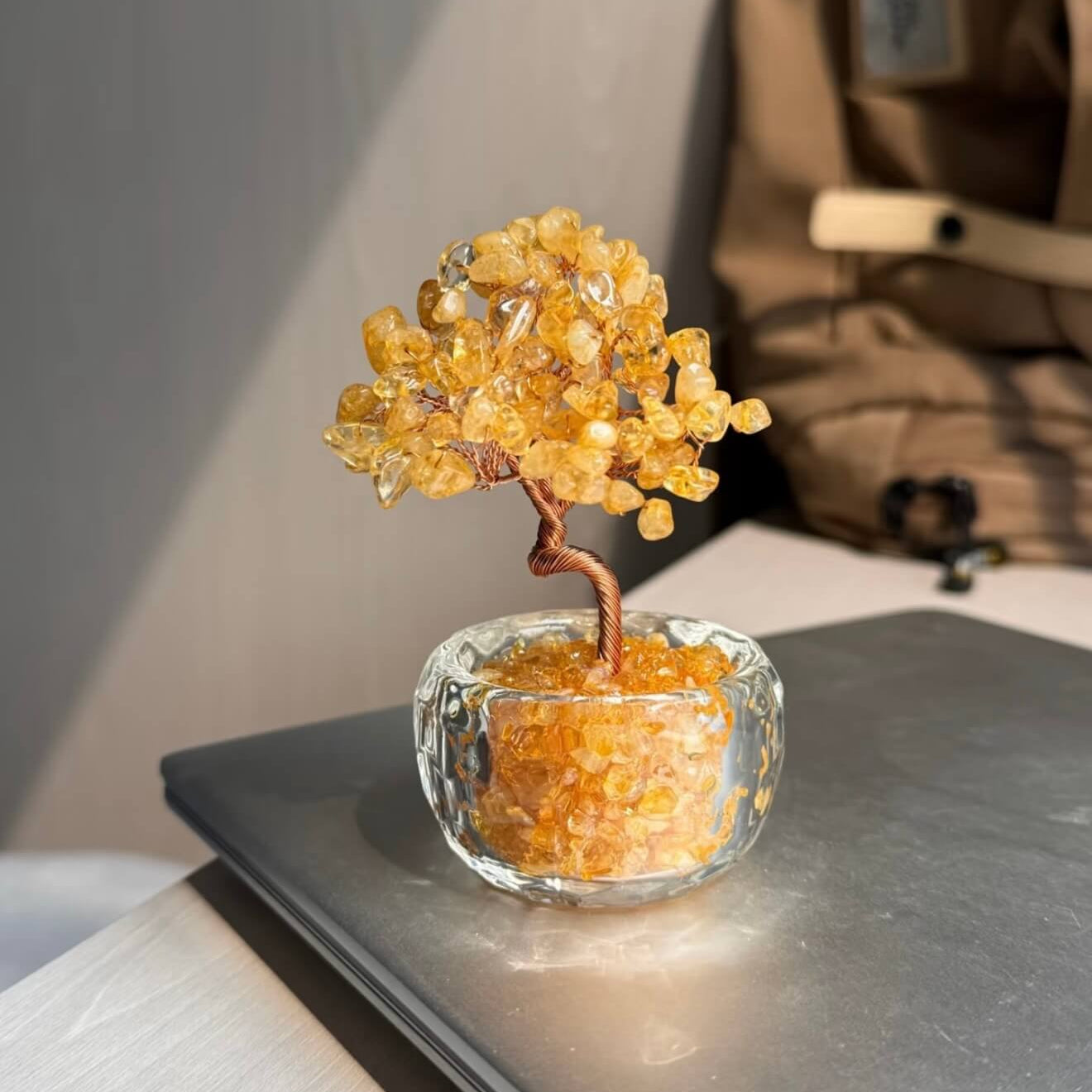 Handcrafted Citrine crystal and copper wire energy tree desk ornament with a minimalist clear glass base filled with golden crystal fragments.