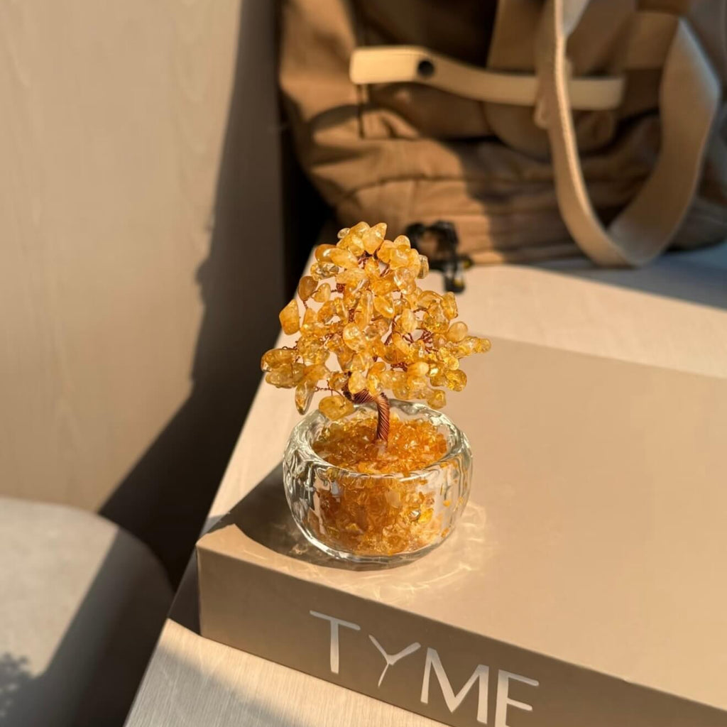 Handcrafted Citrine crystal and copper wire energy tree desk ornament with a minimalist clear glass base filled with golden crystal fragments.