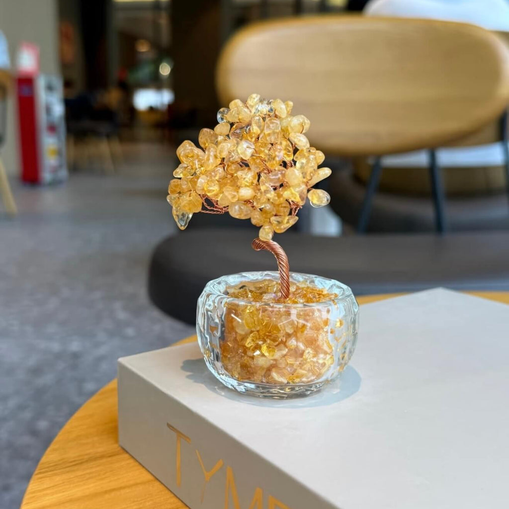 Handcrafted Citrine crystal and copper wire energy tree desk ornament with a minimalist clear glass base filled with golden crystal fragments.