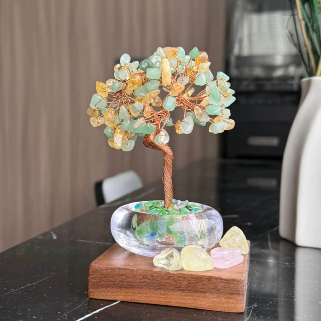 Handcrafted luminous green and yellow Cat's Eye crystal energy tree desk ornament with a minimalist clear glass base filled with translucent crystal fragments.