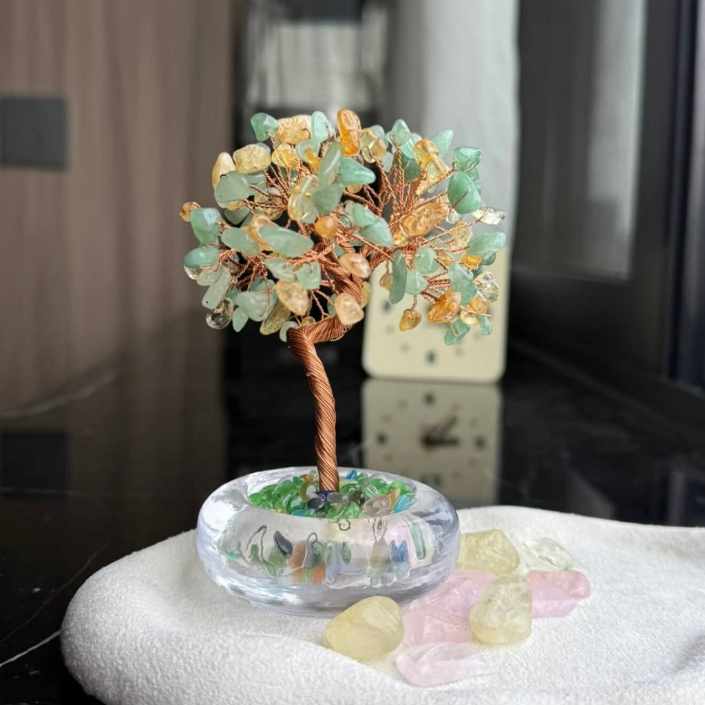 Handcrafted luminous green and yellow Cat's Eye crystal energy tree desk ornament with a minimalist clear glass base filled with translucent crystal fragments.