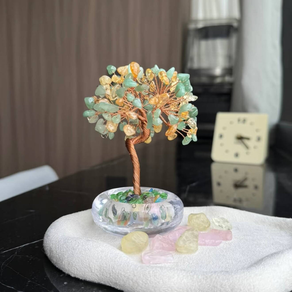 Handcrafted luminous green and yellow Cat's Eye crystal energy tree desk ornament with a minimalist clear glass base filled with translucent crystal fragments.