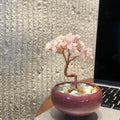 Handcrafted Rose Quartz crystal and copper wire energy tree desk anchor with a minimalist crackle-glaze ceramic basin filled with pastel crystal fragments.