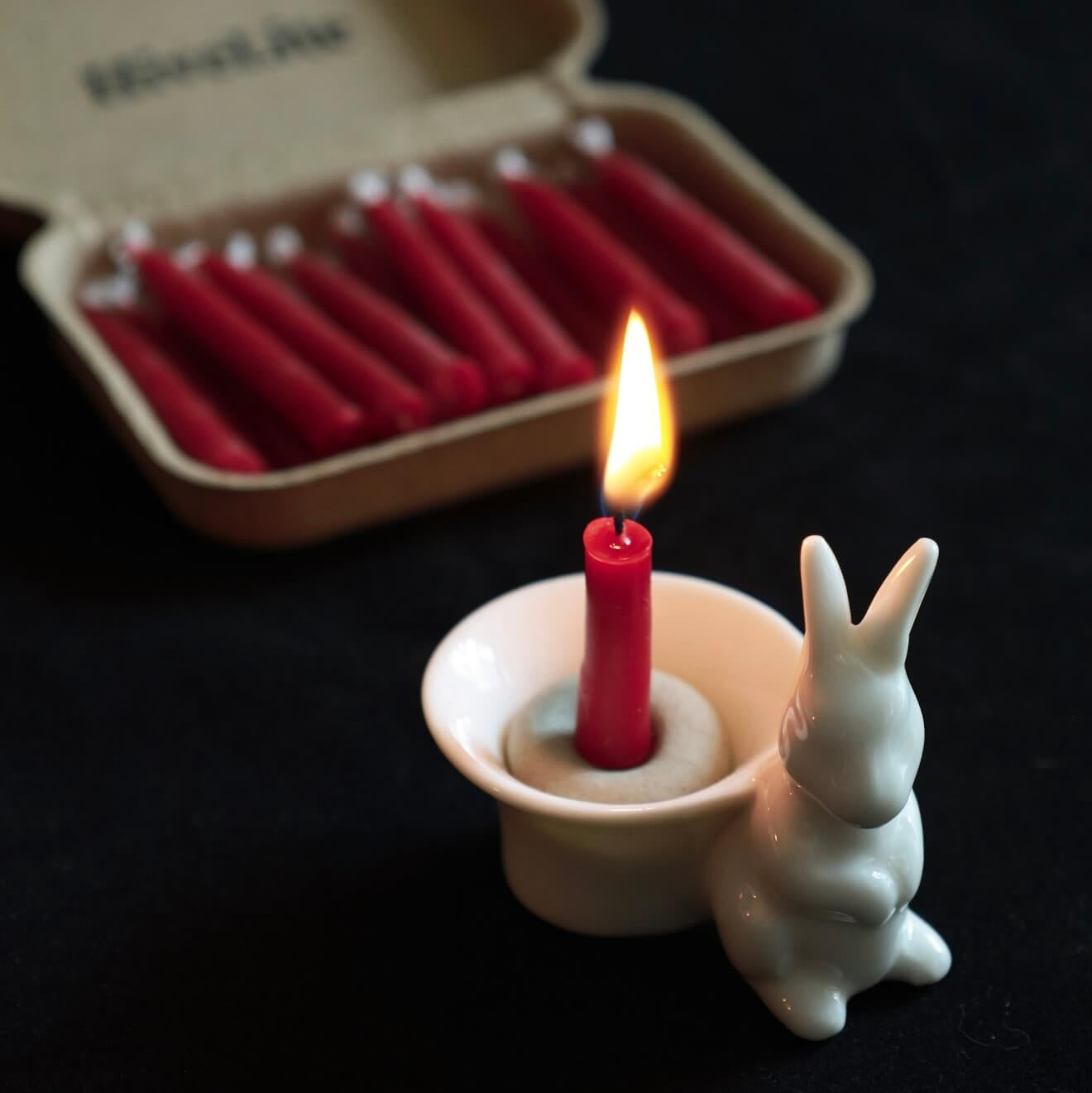 Handcrafted 20-minute Crimson Velvet beeswax meditation candle set by CIRCLEARA, featuring slim red taper candles in a sustainable kraft package with a minimalist ceramic holder.