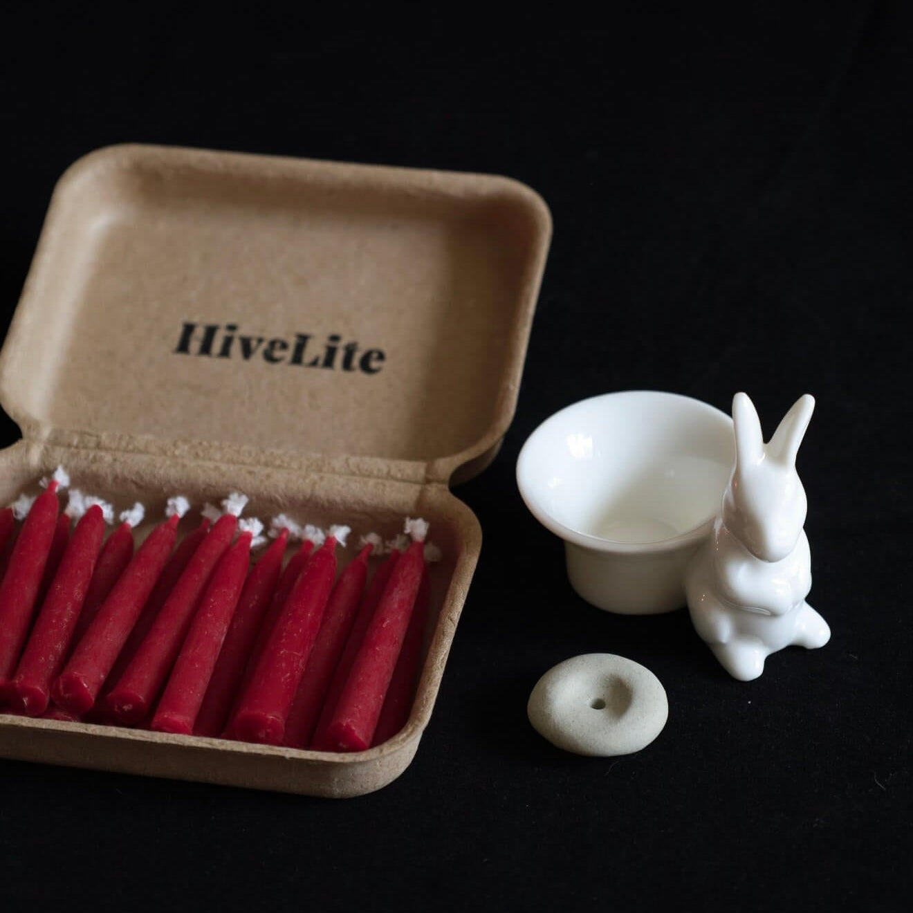Handcrafted 20-minute Crimson Velvet beeswax meditation candle set by CIRCLEARA, featuring slim red taper candles in a sustainable kraft package with a minimalist ceramic holder.