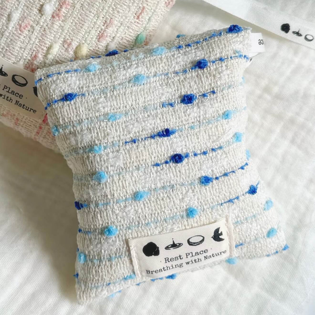 A handcrafted blue and white woven herbal sachet by CIRCLEARA, symbolizing a cool, flowing stream of emotional intuition.