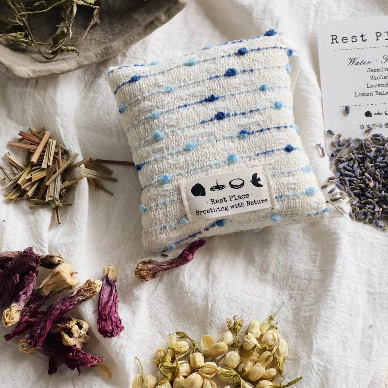 A handcrafted blue and white woven herbal sachet by CIRCLEARA, symbolizing a cool, flowing stream of emotional intuition.