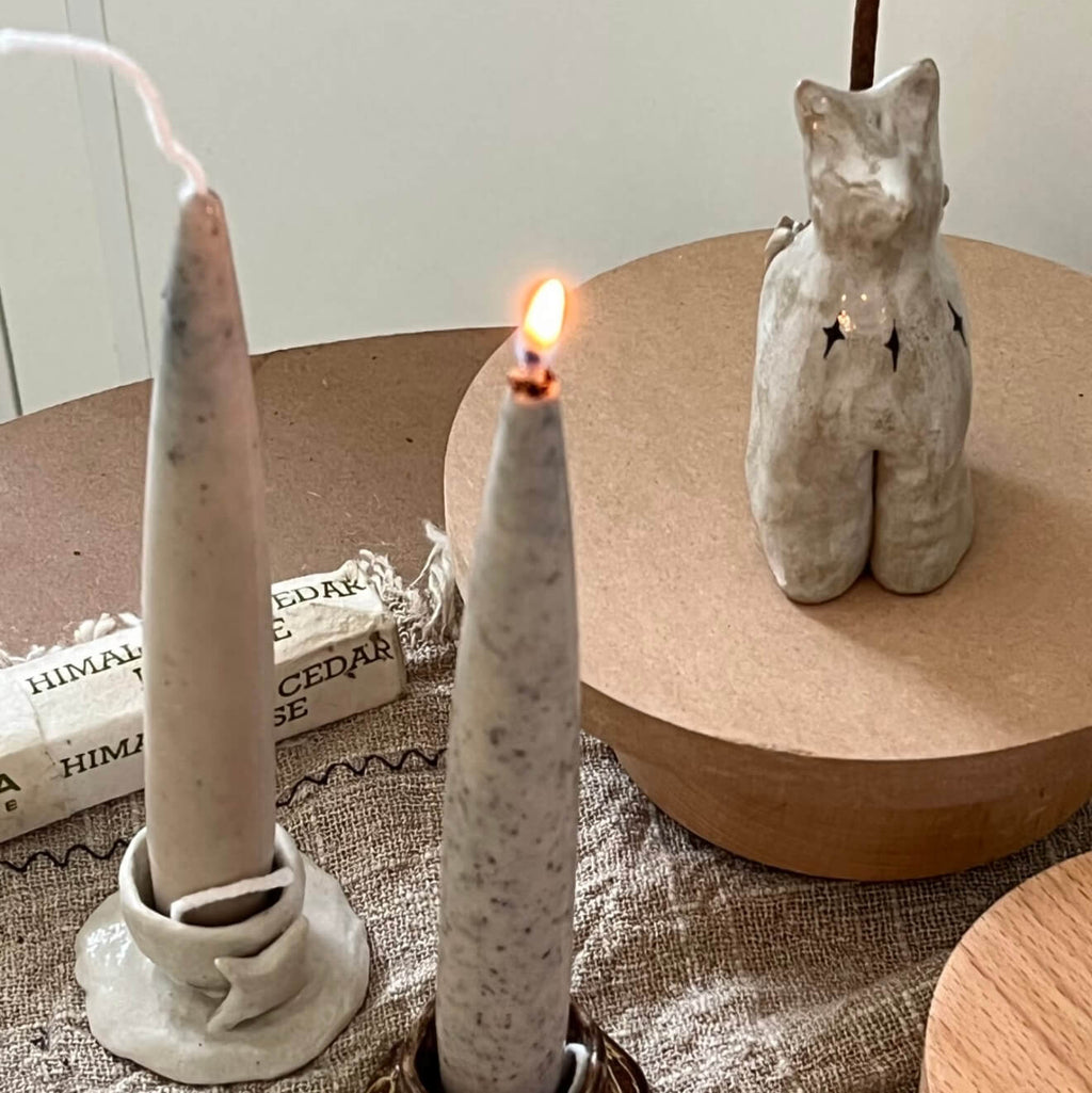 Handcrafted Valley Café coffee-infused soy and beeswax taper candle by CIRCLEARA, featuring a raw, textured surface with natural pinholes and fissures, lit on a minimalist aesthetic background.