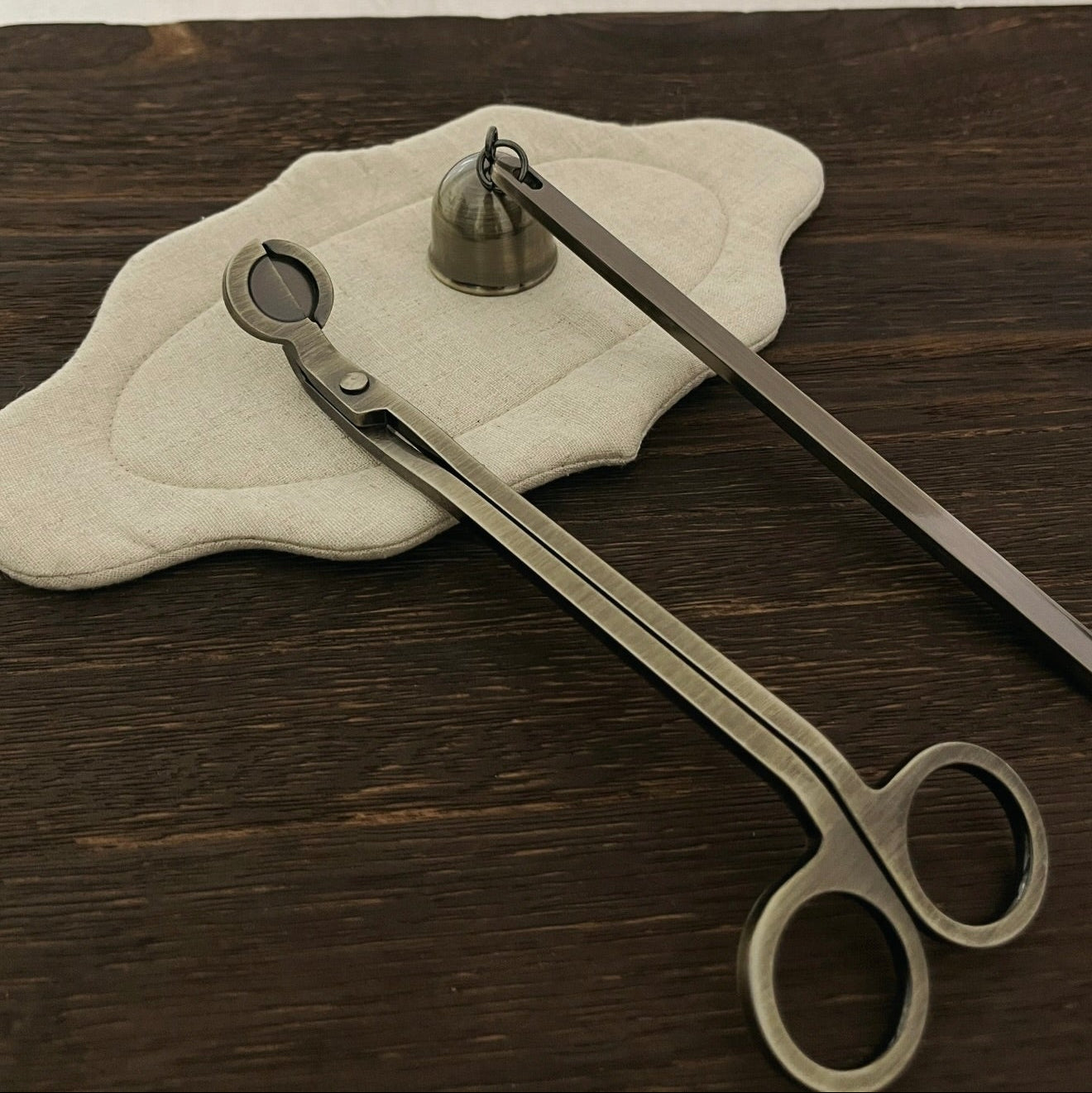 A set of CIRCLEARA candle care ritual tools in five metallic finishes, showing the weighted wick trimmer and bell snuffer in high-detail electroplating.