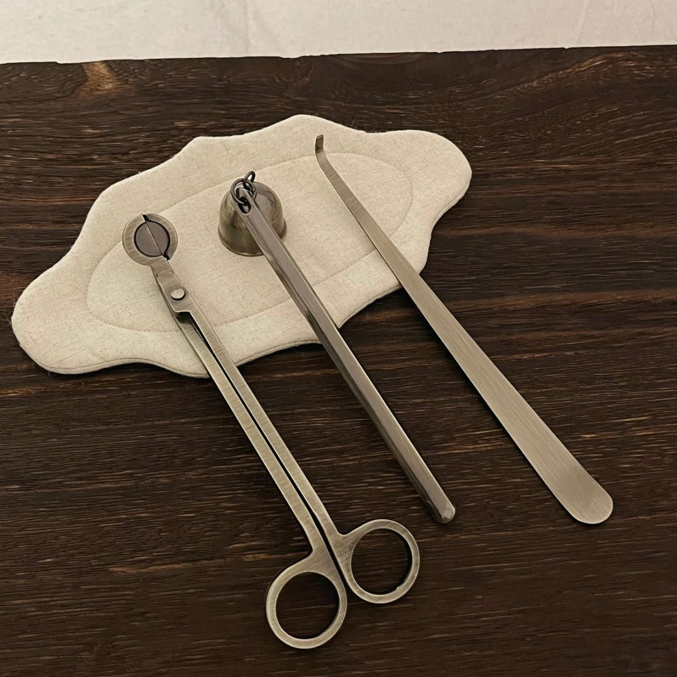 A set of CIRCLEARA candle care ritual tools in five metallic finishes, showing the weighted wick trimmer and bell snuffer in high-detail electroplating.