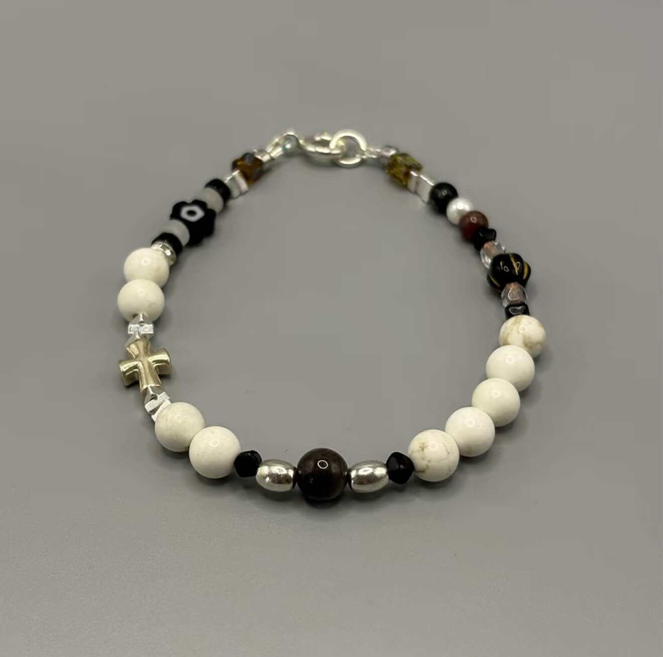 CIRCLEARA Monochrome Muse Bracelet: White howlite beads, silver sheen obsidian, and a sterling silver cross. A luxury minimalist grounding tool for focus and calm.