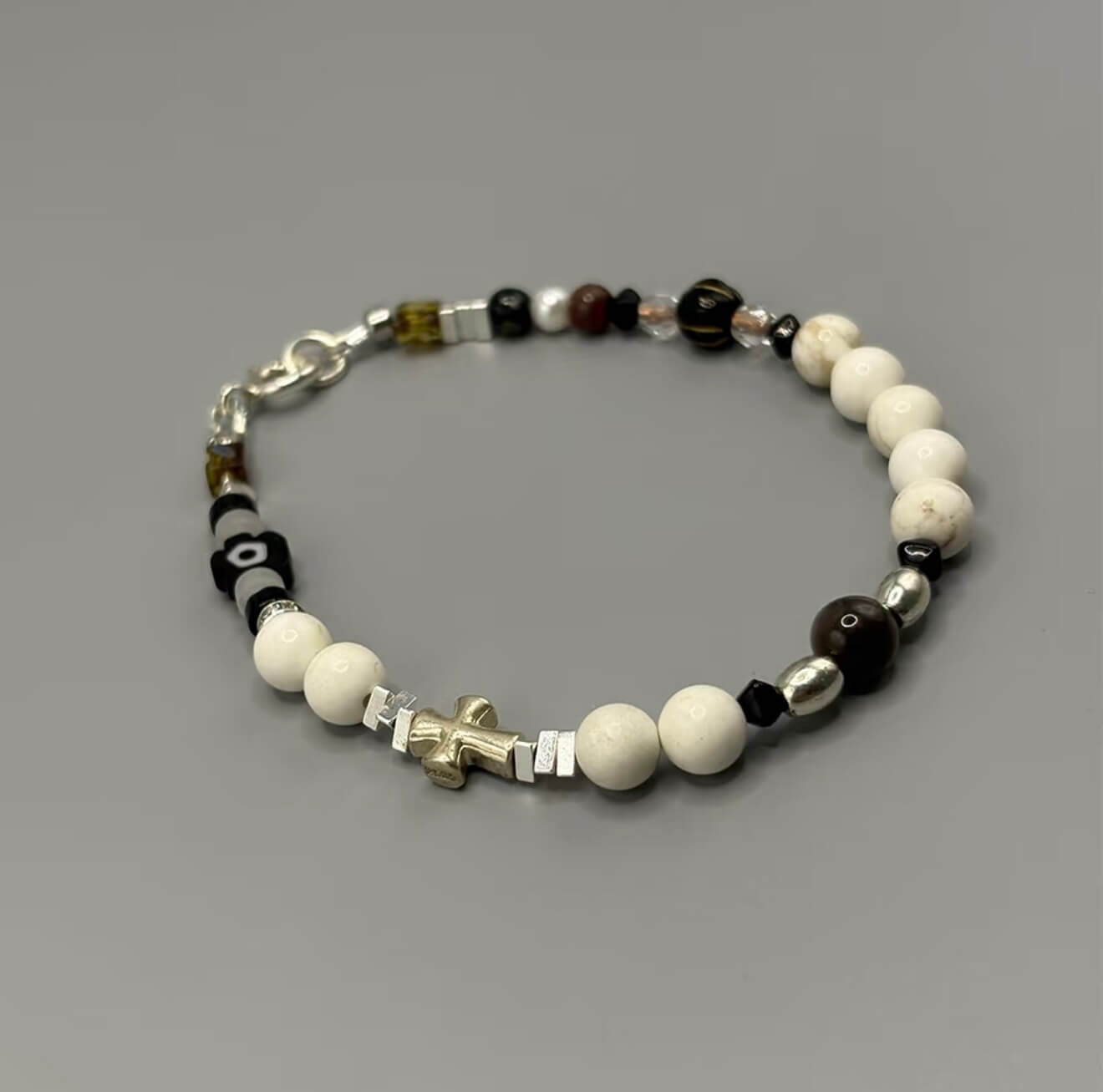CIRCLEARA Monochrome Muse Bracelet: White howlite beads, silver sheen obsidian, and a sterling silver cross. A luxury minimalist grounding tool for focus and calm.