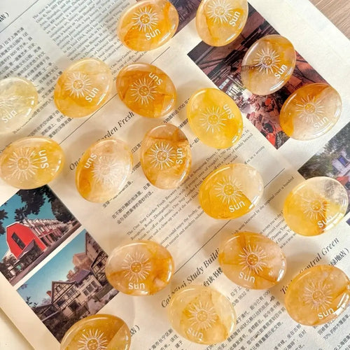 Handcrafted natural golden hematoid yellow quartz palm stones engraved with silver text 'SUN' and a star by CIRCLEARA, displaying vibrant internal inclusions.