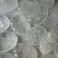 Handcrafted 45mm natural Clear Quartz cosmic palm stones by CIRCLEARA, silver-etched with a crescent moon and starbursts, showing organic internal ice-crack textures.