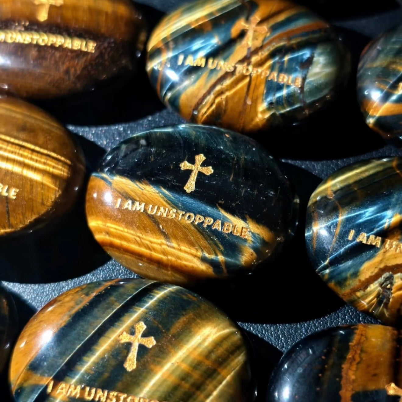 Handcrafted dual Tiger's Eye grounding palm stone by CIRCLEARA, featuring a golden engraved mindfulness quote "I AM UNSTOPPABLE" with rich amber and black banded crystal textures.