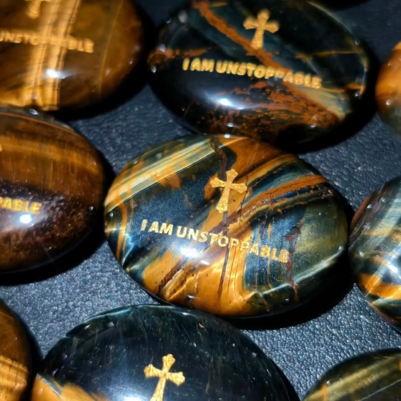 Handcrafted dual Tiger's Eye grounding palm stone by CIRCLEARA, featuring a golden engraved mindfulness quote "I AM UNSTOPPABLE" with rich amber and black banded crystal textures.