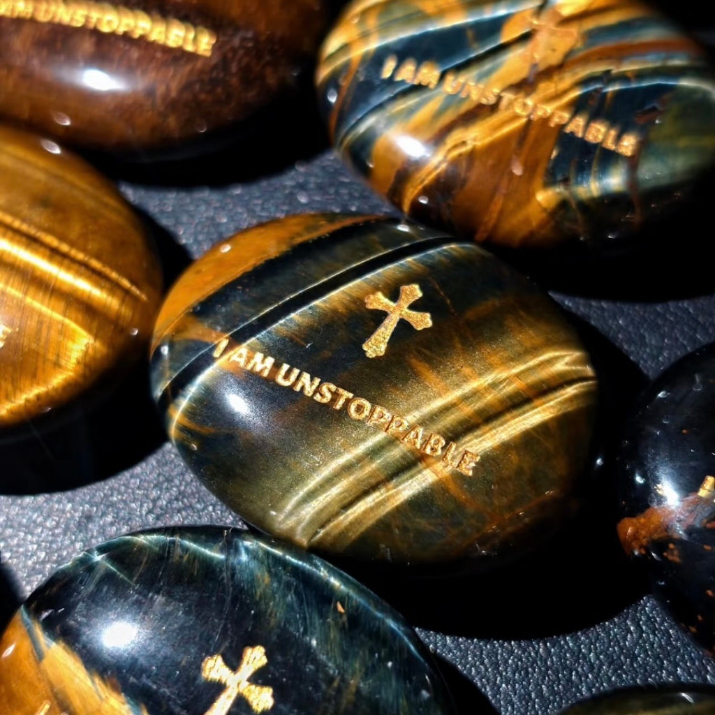 Handcrafted dual Tiger's Eye grounding palm stone by CIRCLEARA, featuring a golden engraved mindfulness quote "I AM UNSTOPPABLE" with rich amber and black banded crystal textures.