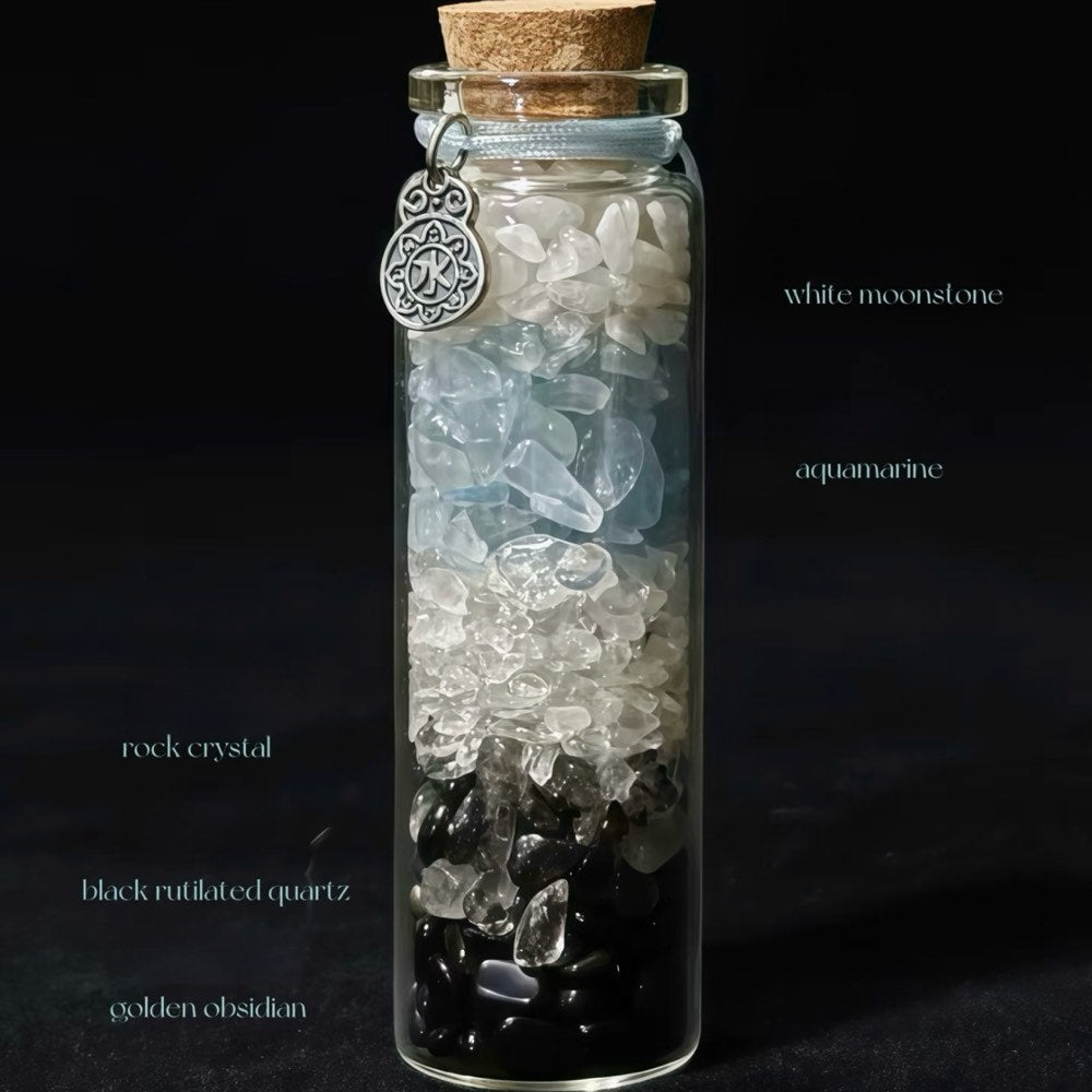 Handcrafted 7x2.2cm glass crystal ritual bottle filled with layered raw mineral chips and a metallic charm by CIRCLEARA.