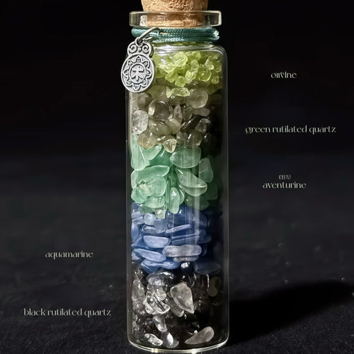 Handcrafted 7x2.2cm glass crystal ritual bottle filled with layered raw mineral chips and a metallic charm by CIRCLEARA.
