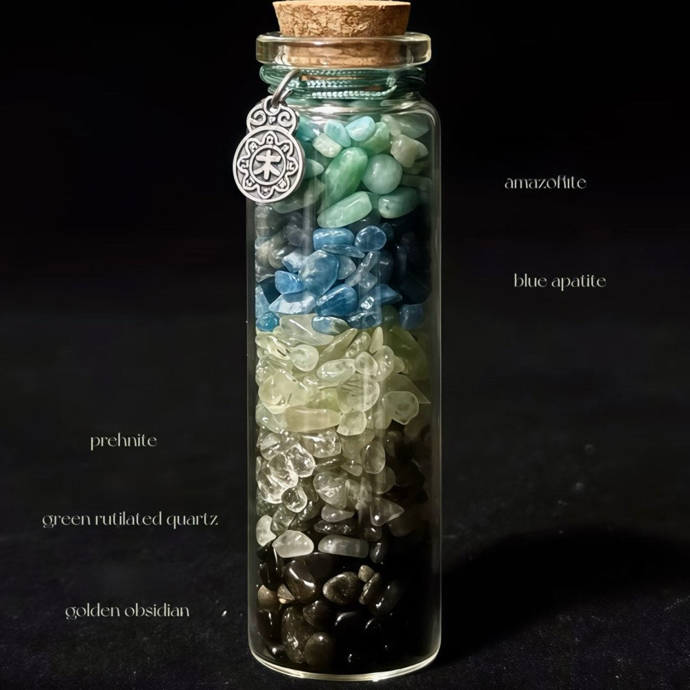 Handcrafted 7x2.2cm glass crystal ritual bottle filled with layered raw mineral chips and a metallic charm by CIRCLEARA.