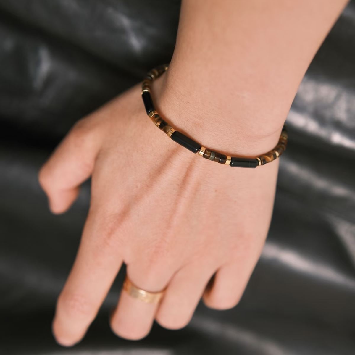 Minimalist men's beaded bracelet featuring polished black obsidian cylindrical bamboo tubes and golden yellow tiger's eye disc spacers by CIRCLEARA.