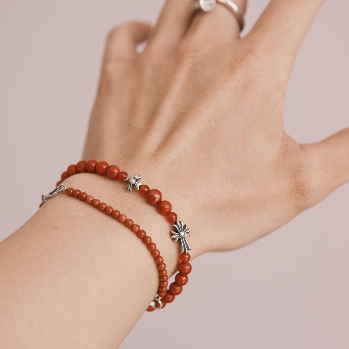 Handcrafted 6.3mm natural cherry-red Nanhong agate beaded bracelet with a 925 sterling silver vintage sunburst charm worn on a wrist, by CIRCLEARA.