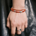 Handcrafted 6.3mm natural cherry-red Nanhong agate beaded bracelet with a 925 sterling silver vintage sunburst charm worn on a wrist, by CIRCLEARA.