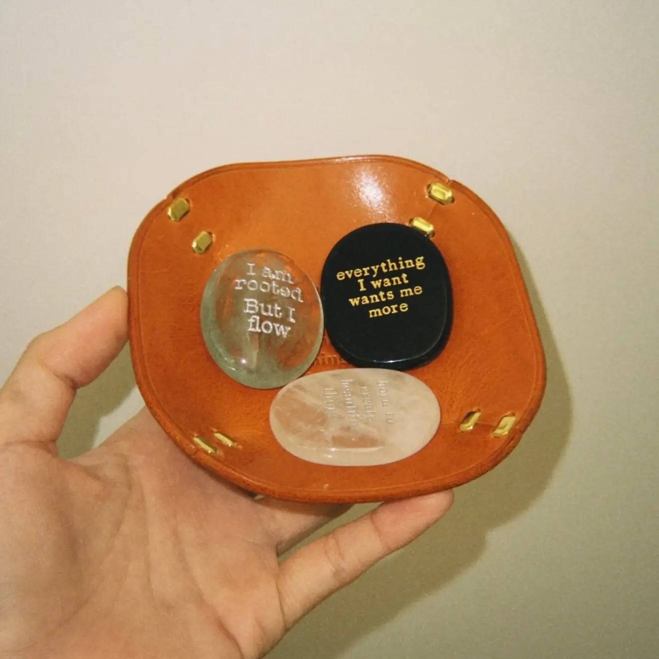 CIRCLEARA "Golden Ticket" manifest stone. Deep sheen mineral with gold-etched motivational mantra, designed as a tactile artifact for owning your abundance.
