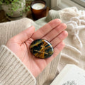 Handcrafted dual Tiger's Eye grounding palm stone by CIRCLEARA, featuring a golden engraved mindfulness quote "I AM UNSTOPPABLE" with rich amber and black banded crystal textures.